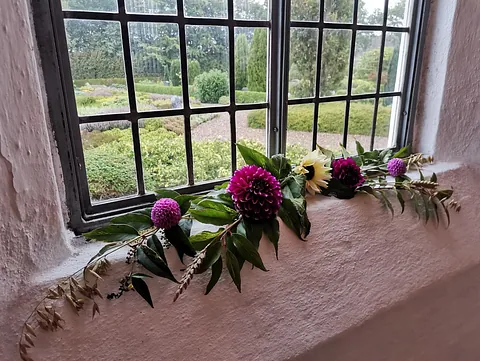 Det indre af en lys kirke set fra midtergangen, der kigger mod alteret.